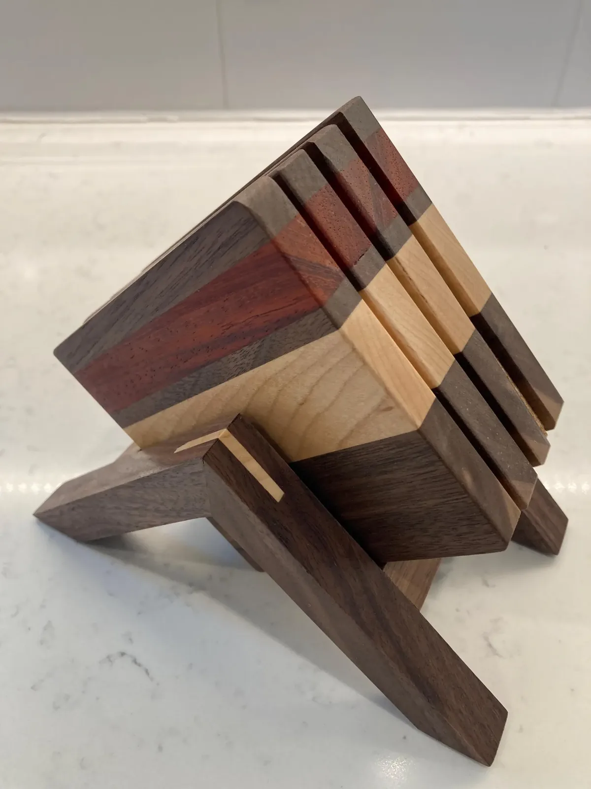 Striped hardwood coasters in a cross-leg walnut stand