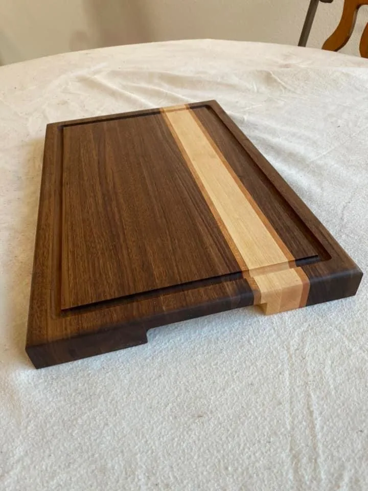 Walnut cutting board with a maple and cherry stripe and a juice groove