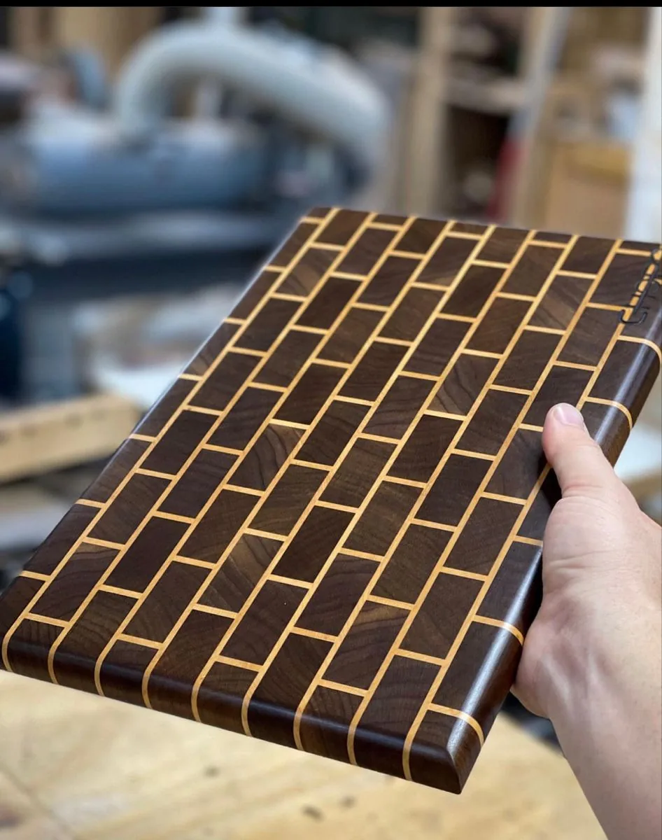 A walnut and maple brick-pattern end-grain board held up in the KJ & Son shop