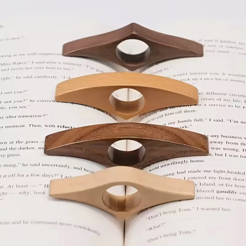 Four wooden thumb page holders resting on an open book